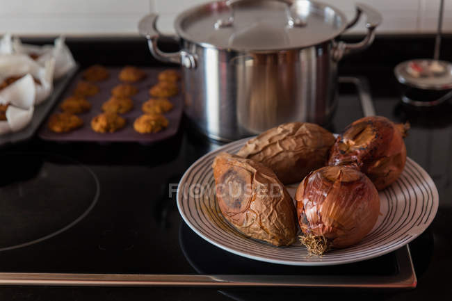 Запечённый лук и сладкий картофель на плите — стоковое фото