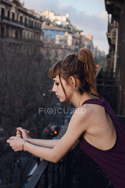 Vue latérale de la fille rousse posant au balcon — Photo de stock
