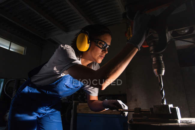 Vista a basso angolo del trapano a colonna operante meccanico femminile — Foto stock