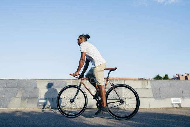 Чорний чоловік їде на велосипеді — стокове фото