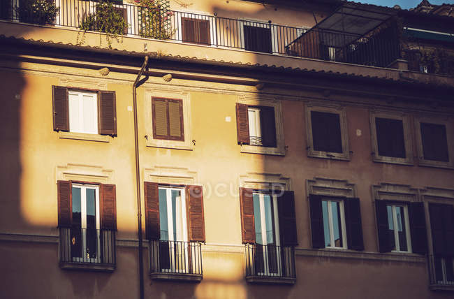 Fachada iluminada do edifício com janelas refletindo raios de sol — Fotografia de Stock