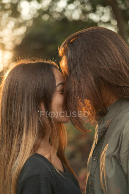 Portrait of boy with long hair hiding face leaning on girlfriend — Stock Photo