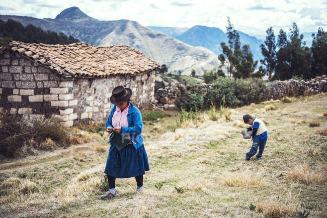 AYACUCHO, PERU '- 30 DICEMBRE 2016: Native mother and child walking in rural field — Foto stock