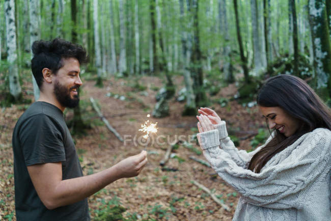 Paar mit Wunderkerzen im Wald — Stockfoto