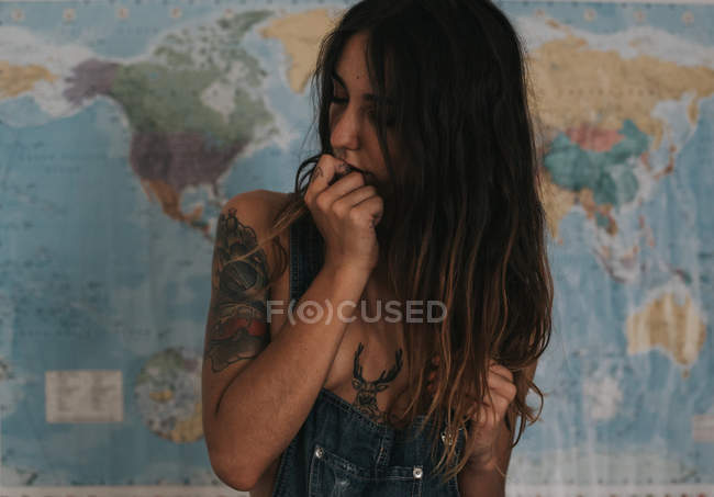 Brünettes Mädchen posiert über Weltkarte — Stockfoto