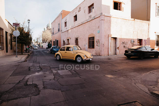 Classic old yellow car riding on streets  street scene — Stock Photo