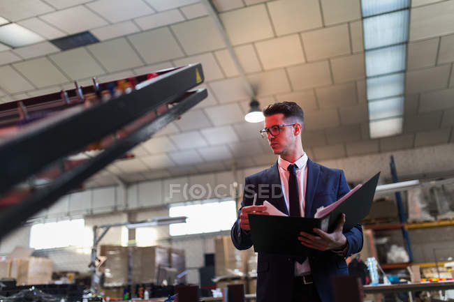Formal man with folder inspecting factory — Stock Photo