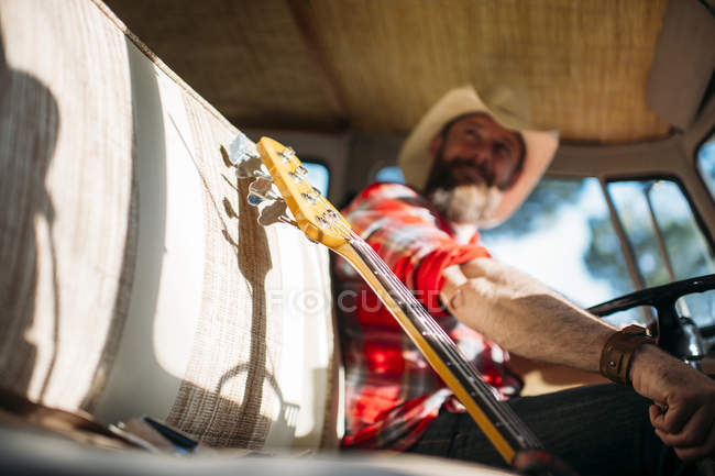Закройте вид на горлышко бас-гитары на переднем сиденье фургона — стоковое фото