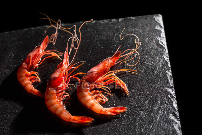 Delicious fresh prawns on black stone background. — Stock Photo