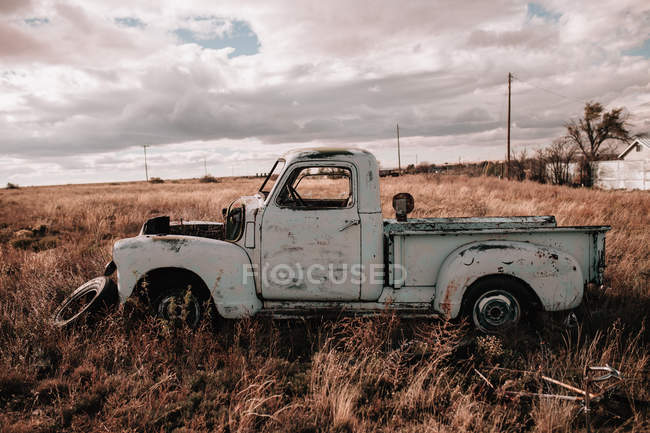Viejo camión abandonado en el campo en día nublado - foto de stock