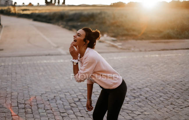 Вид збоку сміється брюнетка дівчина на парковій алеї — стокове фото