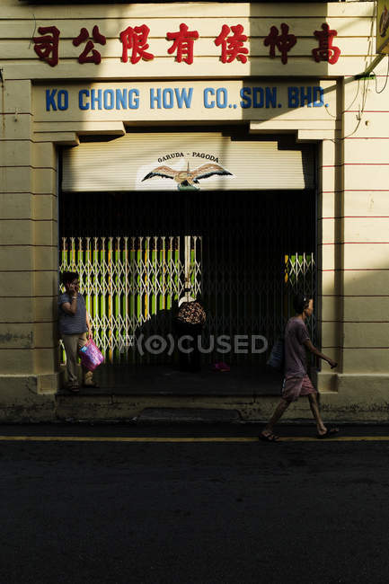 KAULA LUMPUR, MALASIA - 15 ABRIL, 2016: Vista lateral de personas caminando por la calle con letreros en las fachadas - foto de stock