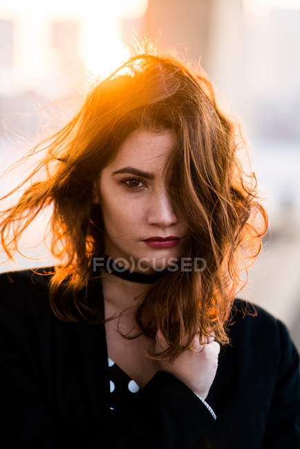 Портрет серьезной женщины, смотрящей в камеру при тёплом солнечном свете — стоковое фото