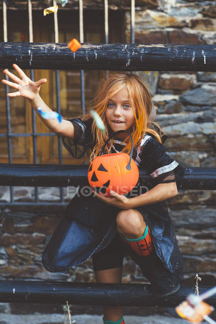 Girl throwing candies from bucket — Stock Photo