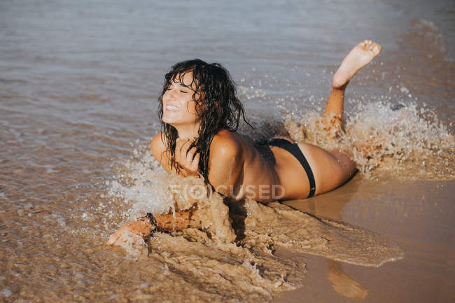 Portrait of topless woman with wet hair washed with surfing wave on beach — Stock Photo