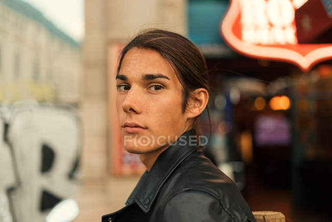 Portrait of boy with long hair looking over shoulder at camera — Stock Photo