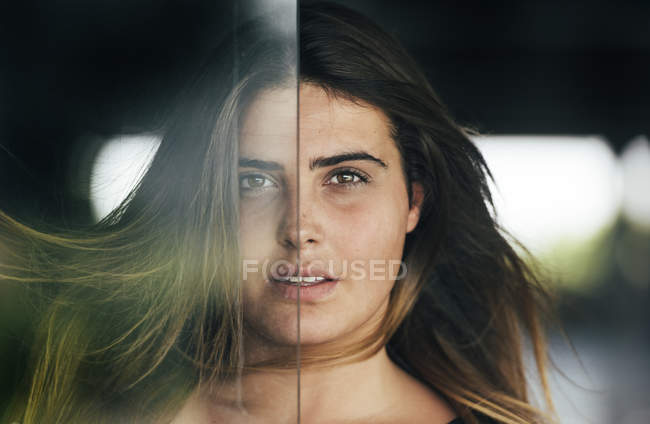 Женщина смотрит в камеру за стеклом — стоковое фото