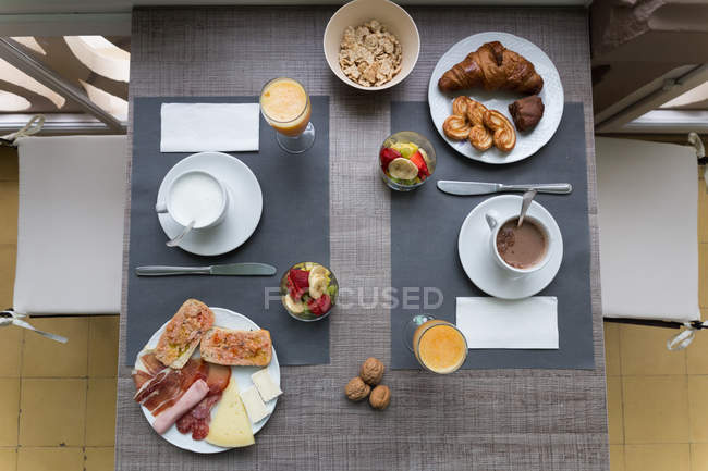 Vista superior de la mesa con desayuno servido - foto de stock