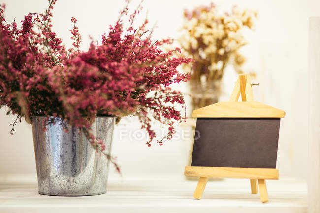 Secchio di fiori di campo rosa con lavagna — Foto stock