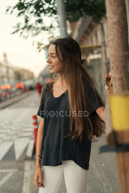 Ritratto di ragazza bruna che posa sulla scena di strada e distoglie lo sguardo — Foto stock