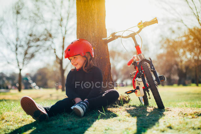 Fille au repos après avoir monté son vélo dans le parc — Photo de stock
