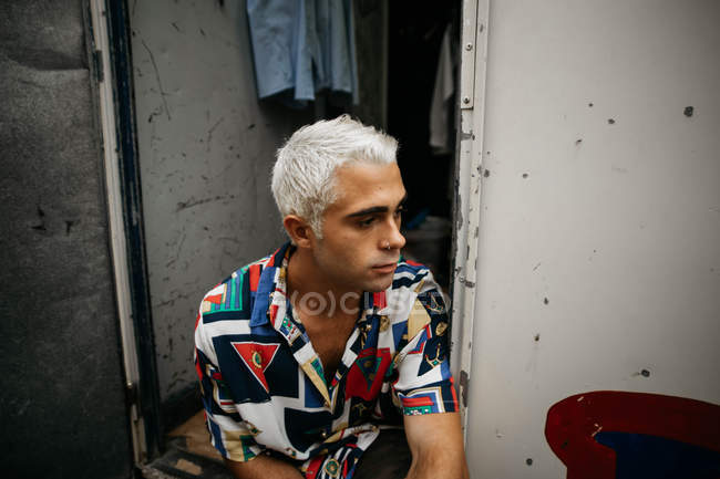 Homem com cabelo branqueado olhando para longe — Fotografia de Stock