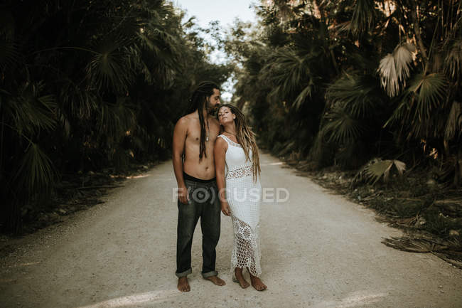 Portrait of couple with dreadlocks posing on tropical road — Stock Photo