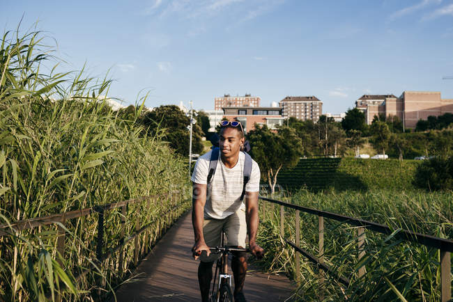 Uomo in sella alla bicicletta sul lungomare — Foto stock