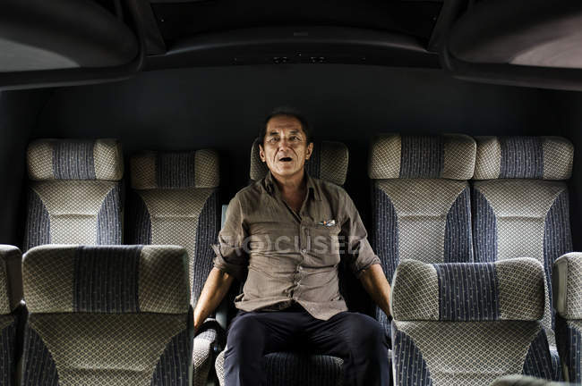 KAULA LUMPUR, MALASIA- 1 MAY, 2016: Senior man sitting on seat in bus with expression of enjoyment. — Stock Photo