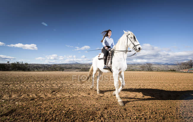 Portrait of woman riding white horse on rural field at countryside — Stock Photo