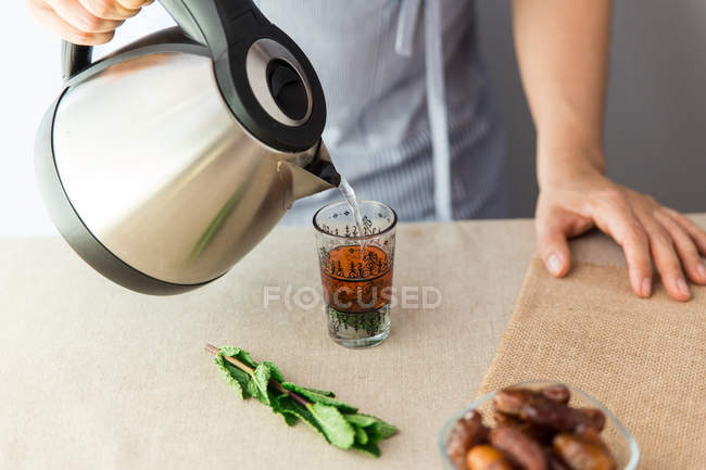Cook adding boiling water in glass — Stock Photo