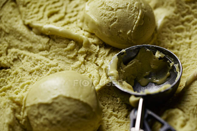 Full frame shot of pistachio ice-cream balls and scoop — Stock Photo