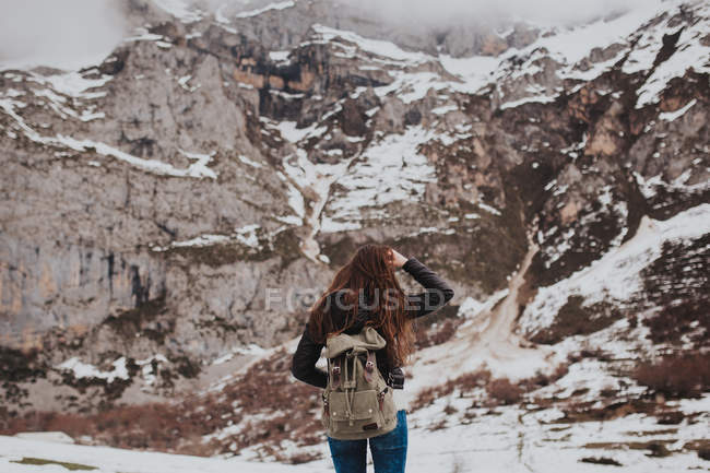 Вид сзади на брюнетку туриста, стоящую в зимних горах — стоковое фото