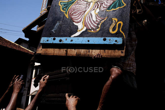 Gente anónima manos en la calle bajo tablero de madera pintado colgando . - foto de stock
