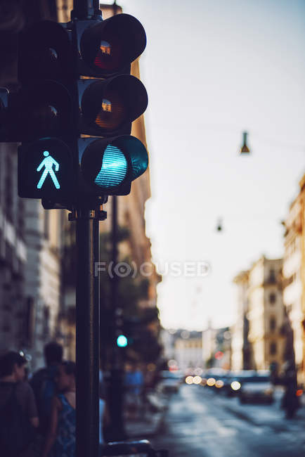 Green light on traffic light post at street scene — Stock Photo