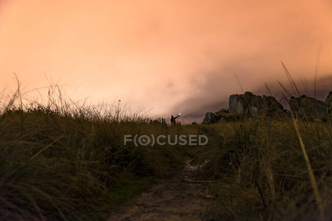 Человек с фонариком ночью в горах под густым туманом — стоковое фото