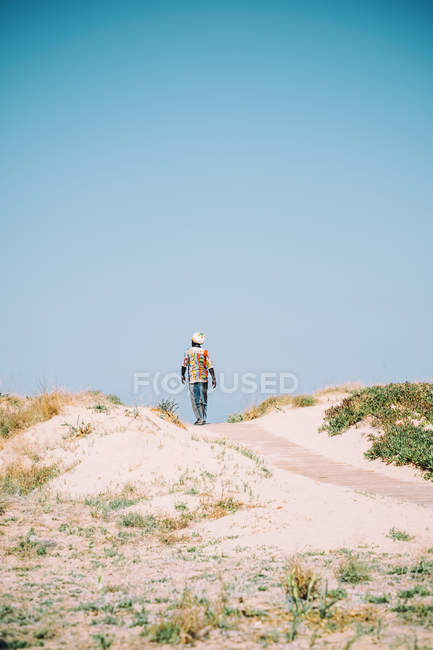 L'uomo in cammino su passerella di legno in sabbia — Foto stock