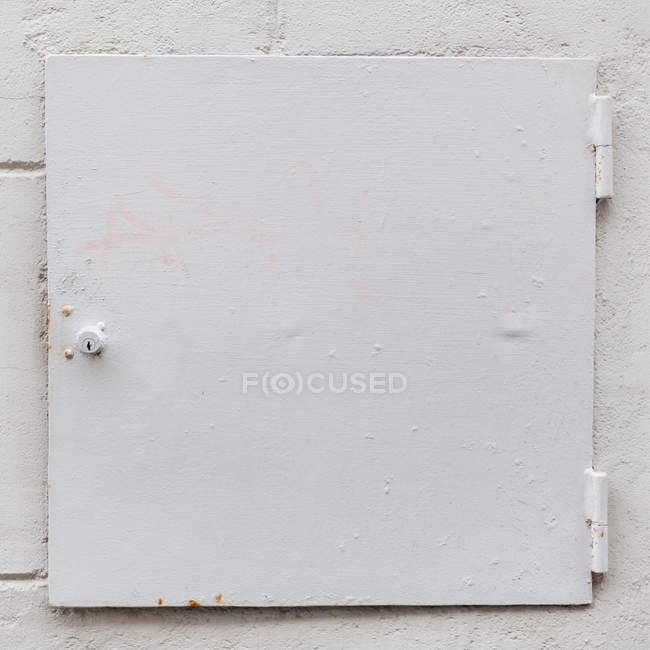 Cofre de aço branco na parede rebocada branca . — Fotografia de Stock