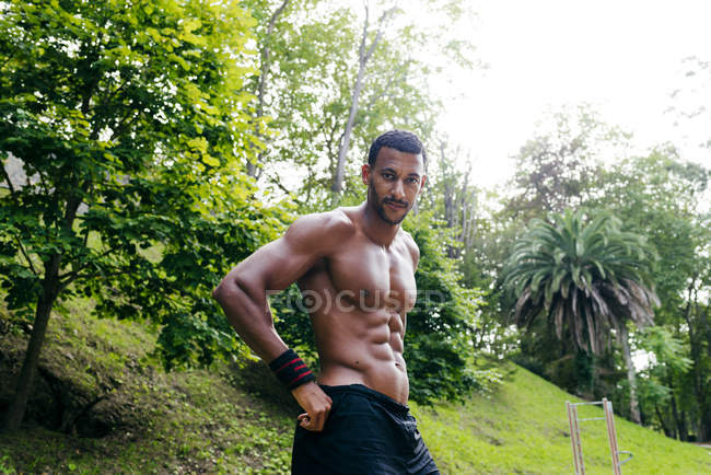 Muscular man posing in park — Stock Photo