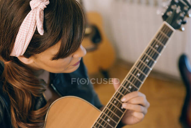 Giovane donna che registra chitarre e presso il suo studio di registrazione a casa. — Foto stock