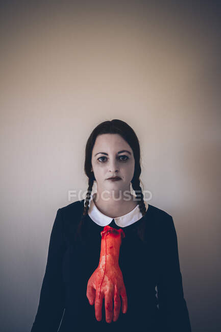 Retrato de niña con la piel pálida vestido negro y la mano ensangrentada como corbata. Espacio de copia. - foto de stock