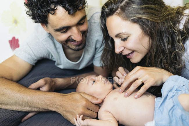 Felice giovane coppia petting neonato figlio — Foto stock