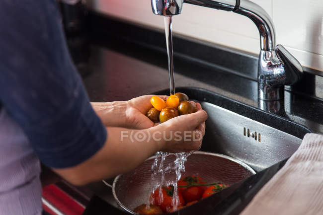 Koch wäscht frische Tomaten — Stockfoto