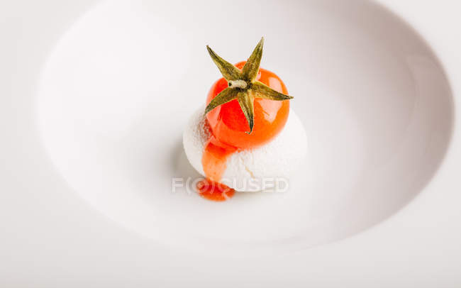 Close up view of dish with little tomato on white cheese. — Stock Photo