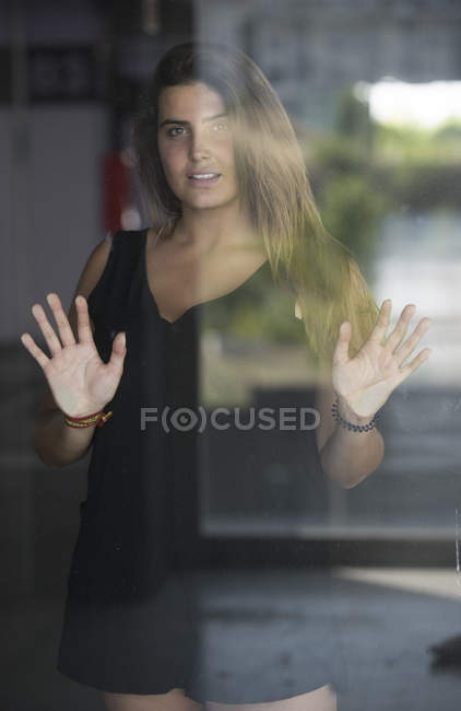 Mulher encostada às palmas das mãos em vidro — Fotografia de Stock