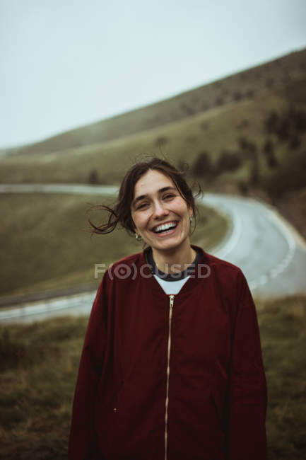Сміється жінка позує на дорозі в полі — стокове фото