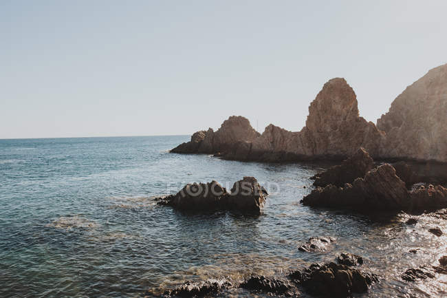 Пейзаж кам'янистої берегової лінії на сонячному світлі — стокове фото