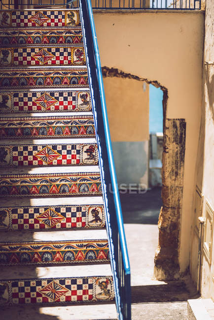 Sonnenbeschienene Treppe mit Keramikfliesen über Torbogen verziert — Stockfoto