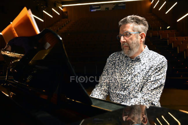 Homem sênior tocando piano no palco — Fotografia de Stock