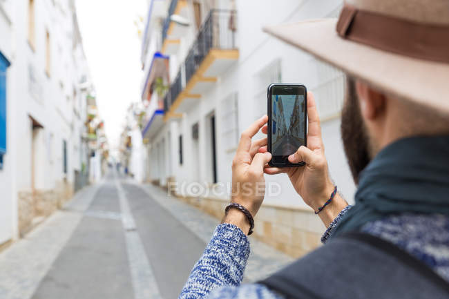 Sobre a visão do ombro do homem barbudo tomando tiro de rua com smartphone . — Fotografia de Stock
